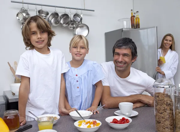 Lächelnde Familie bereitet Frühstück zu — Stockfoto