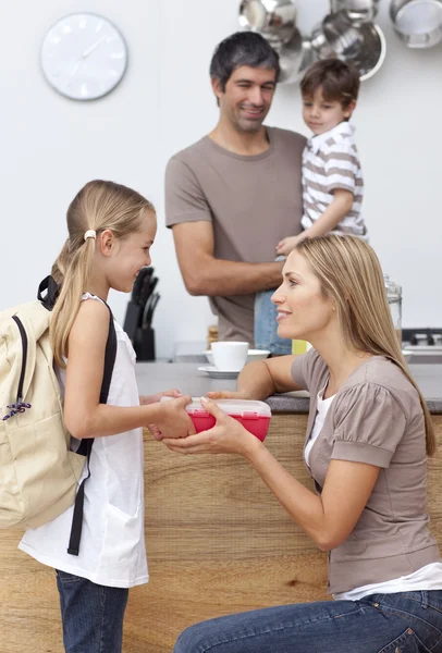Mother giving her daughter the school lunch — Stock Photo, Image