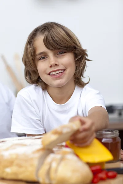 Niño sonriente comiendo pan —  Fotos de Stock