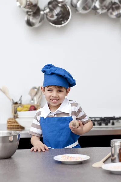Niño con sombrero azul y delantal de la hornada — Stok fotoğraf