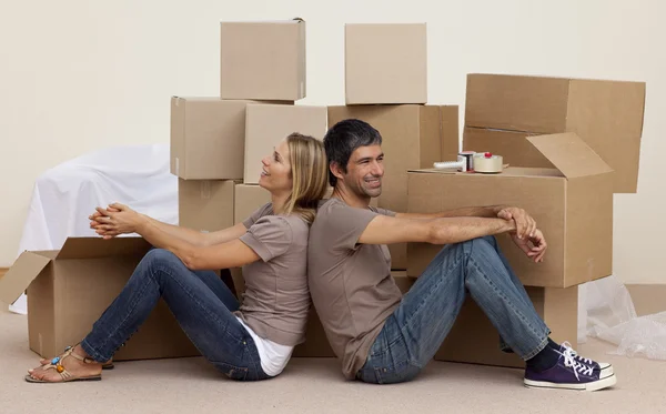 Szczęśliwa para siedzi na podłodze rozpakowaniu pudełka — Zdjęcie stockowe
