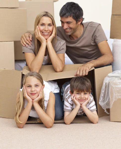 Семья переезжает дом играть с коробками — стоковое фото