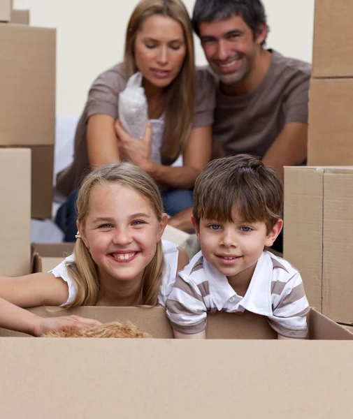 Retrato de crianças desempacotando caixas com seus pais — Fotografia de Stock