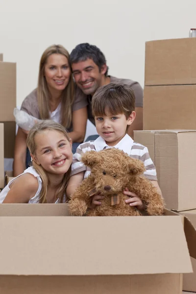Children unpacking boxes with their parents — Stock Photo, Image