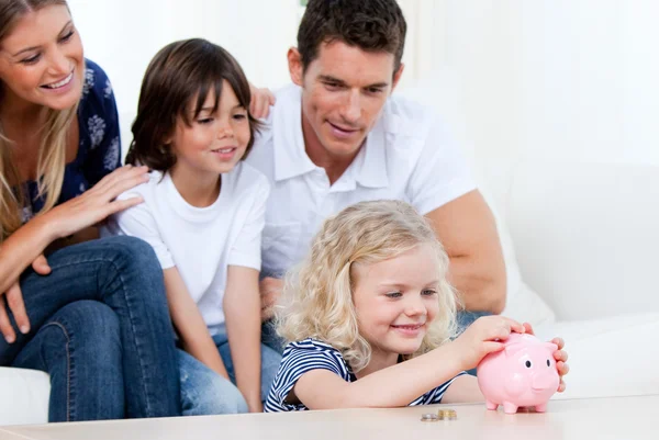 Positive Familie mit Sparschwein — Stockfoto