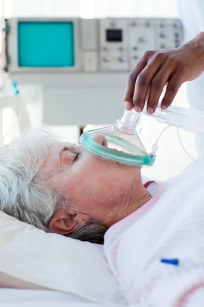 Um médico colocando máscara de oxigênio em um paciente — Fotografia de Stock