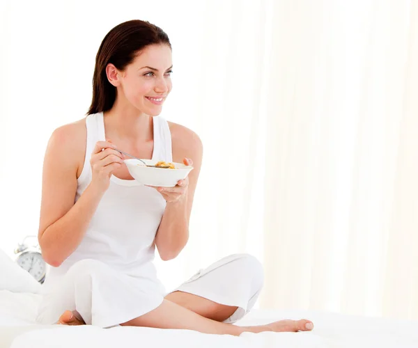 Fröhliche Frau frühstückt sitzend auf ihrem Bett — Stockfoto