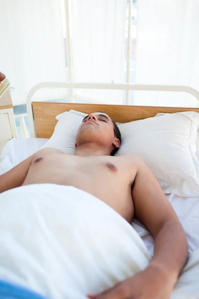 Młodego pacjenta leżącego na łóżku szpitalnym — Zdjęcie stockowe