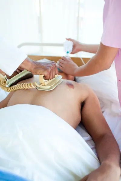 Um médico fazendo uma RCP com um desfibrilador em um paciente — Fotografia de Stock