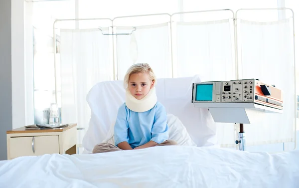 Upset patient with a neck brace sitting on a hospital bed — Stock Photo, Image