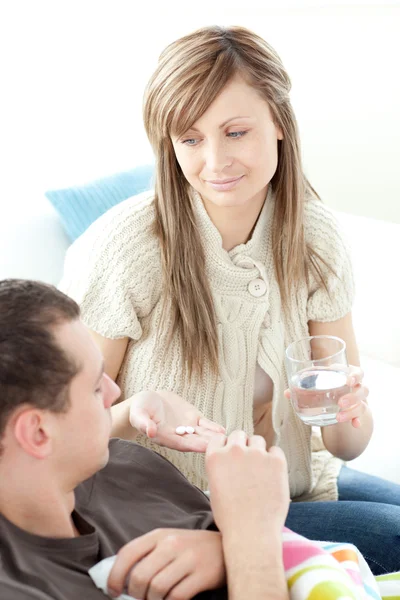 Bright woman give medicine to her husband her husband — Stock Photo, Image