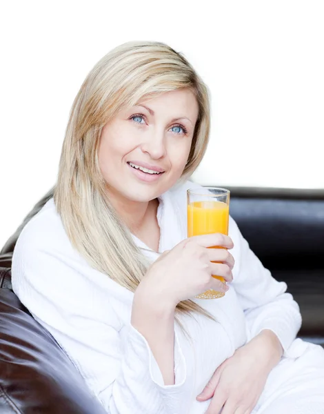 Strahlende Frau trinkt einen orangefarbenen Jus — Stockfoto