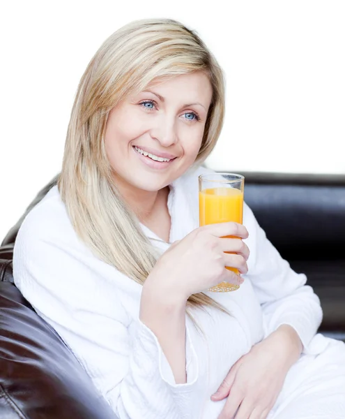 Lächelnde Frau trinkt einen orangefarbenen Jus — Stockfoto