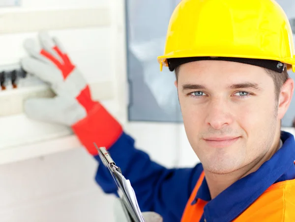 Smiling electrician repairing a power plan — Stock Photo, Image