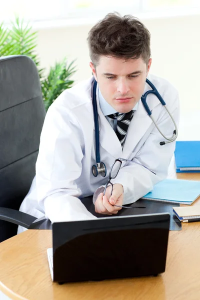Confident male doctor using a laptop — Stock Photo, Image
