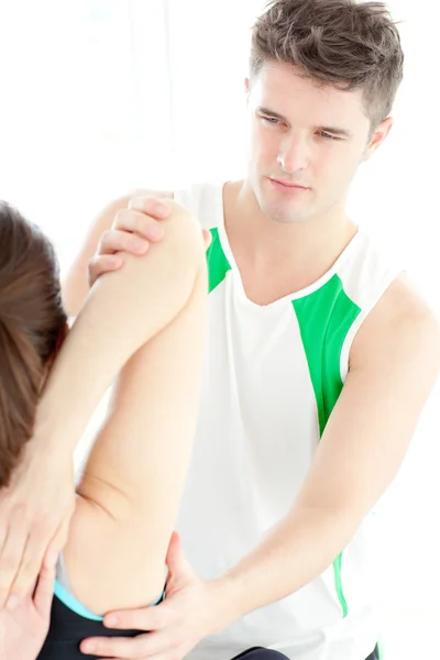 Jistý fyzioterapeut kontrolu ženské rameno — Stock fotografie