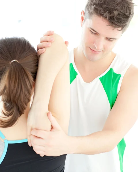 Jovem fisioterapeuta checando o ombro de uma mulher — Fotografia de Stock