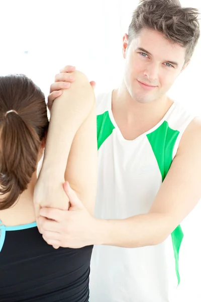 Smiling physical therapist checking a woman's shoulder — Stock Photo, Image