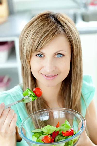 Donna radiosa che mangia un'insalata in cucina — Foto Stock