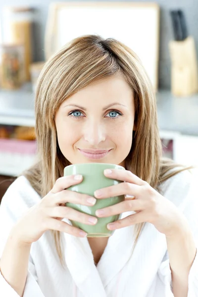 Веселая женщина держит чашку кофе на кухне — стоковое фото