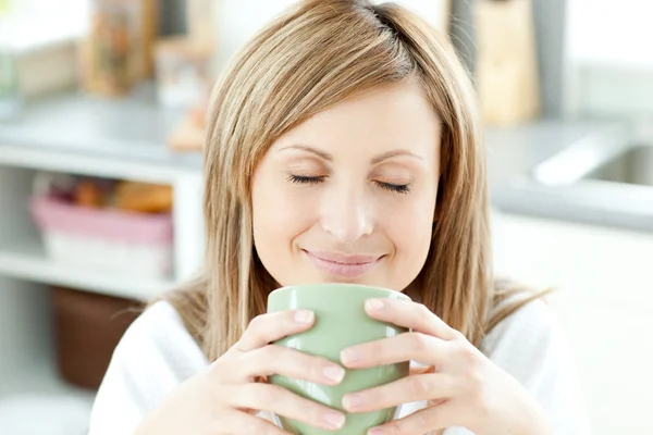 Femme lumineuse tenant une tasse de café dans la cuisine — Photo