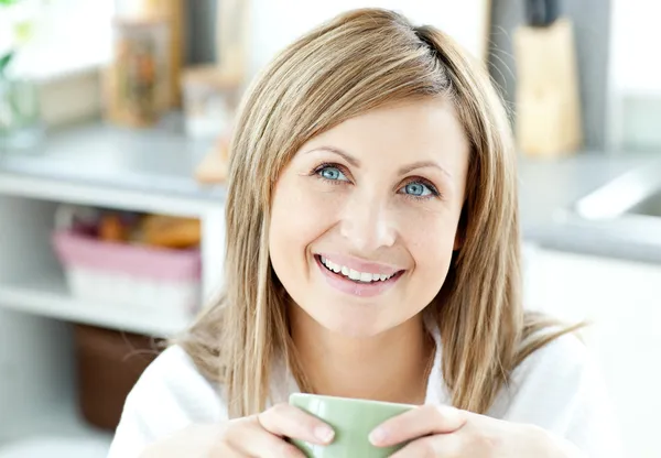 Счастливая женщина держит чашку кофе на кухне — стоковое фото