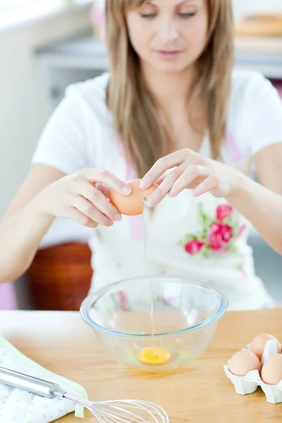 Улыбающаяся женщина готовит яйца на кухне — стоковое фото