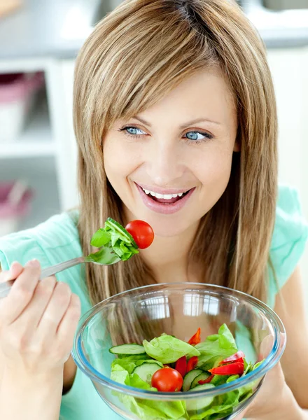 Mujer linda comiendo una ensalada en la cocina —  Fotos de Stock