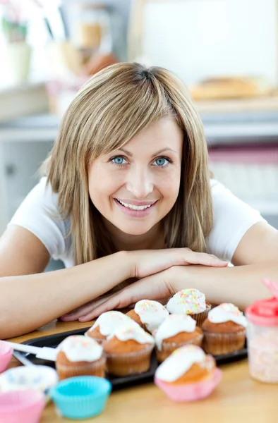 Verheugd vrouw eten gebak in de keuken — Stockfoto