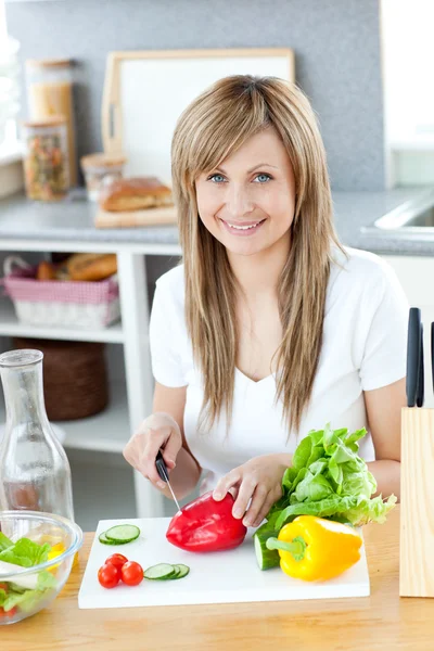 Dospívající žena připravuje salát v kuchyni — Stock fotografie