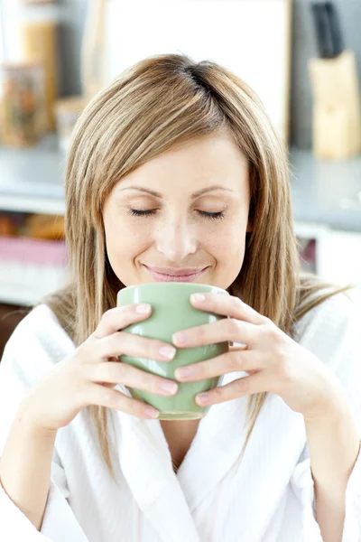 Χαρά γυναίκα, κρατώντας ένα φλιτζάνι τσάι στην κουζίνα — Φωτογραφία Αρχείου