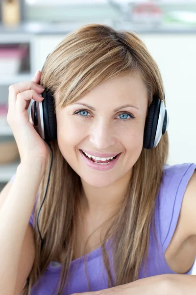 Delighted woman using headphone in the kitchen — Stock Photo, Image