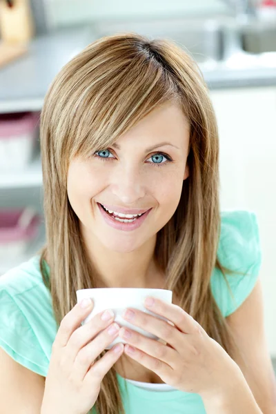 Mulher encantada segurando uma xícara de chá na cozinha — Fotografia de Stock