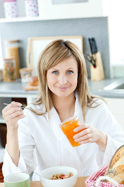 Задоволена жінка снідає на кухні — стокове фото