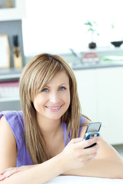 Adolescente mujer enviando un texto en la cocina —  Fotos de Stock