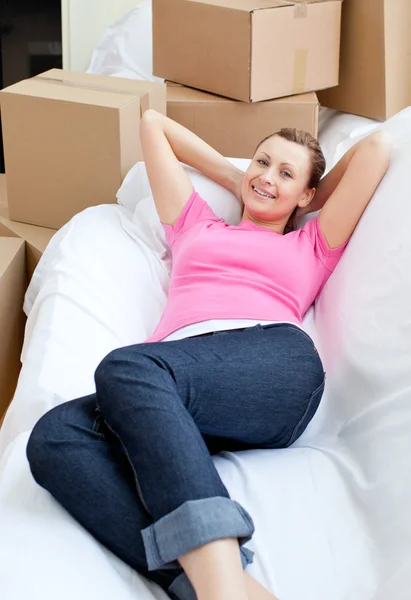 Schöne Frau entspannt sich auf einem Sofa mit Boxen — Stockfoto