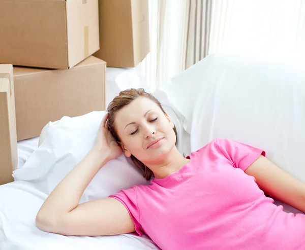 Donna addormentata rilassante su un divano con scatole — Foto Stock