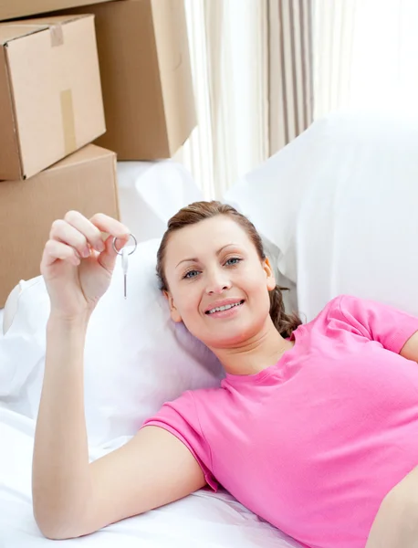 Freudige Frau entspannt sich auf einem Sofa mit Schachteln — Stockfoto