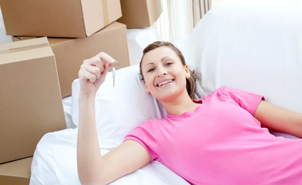 Selbstbewusste Frau entspannt auf einem Sofa mit Schachteln — Stockfoto