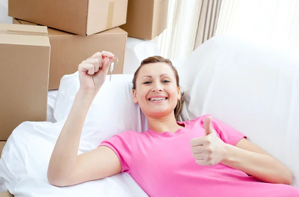 Позитивная женщина отдыхает на диване с коробками — стоковое фото