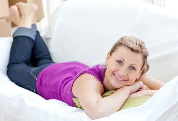 Retrato de una mujer positiva relajándose en un sofá con cajas —  Fotos de Stock