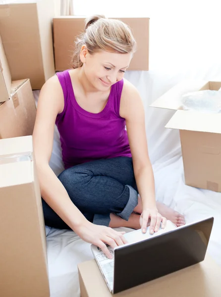 Женщина использует ноутбук при распаковке коробки — стоковое фото