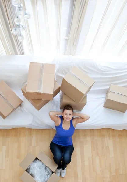 Donna esausta seduta tra le scatole a casa — Foto Stock