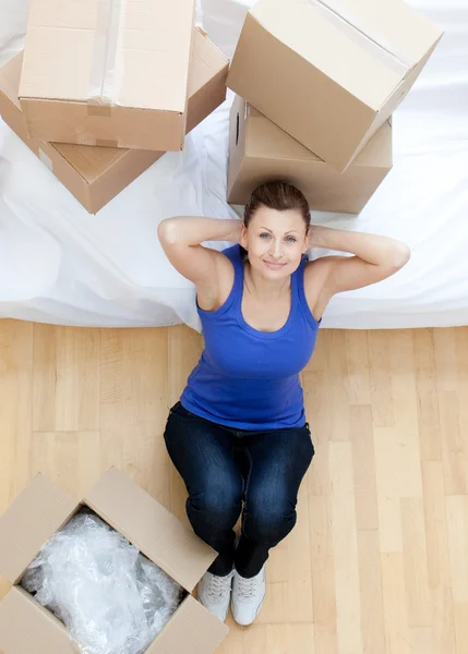 Relaxado mulher sentado entre caixas em casa — Fotografia de Stock