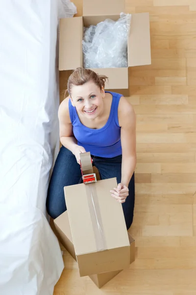 Sorrindo mulher fechando uma caixa — Fotografia de Stock