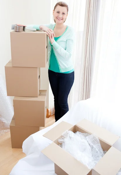 Smiling woman closing various boxes — Stock Photo, Image