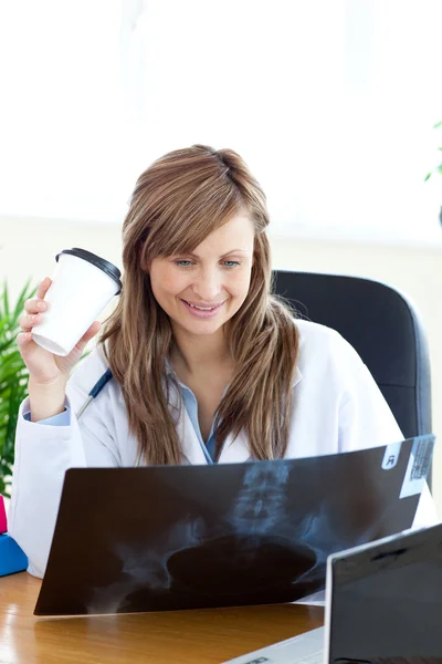 Happy female doctor looking at a radiography — Stock Photo, Image