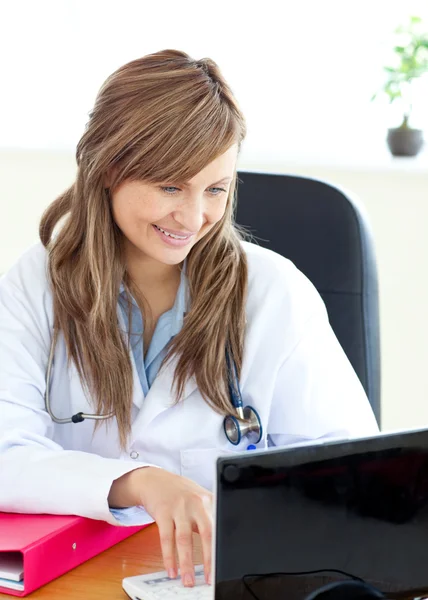 Sorridente medico femminile che lavora con un computer portatile — Foto Stock