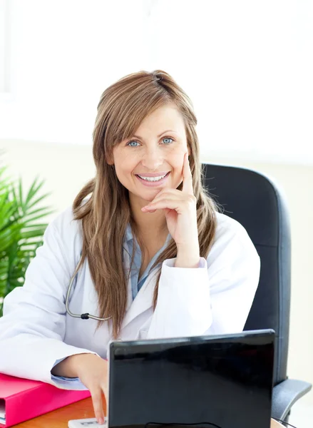 Médico feminino atraente trabalhando com um laptop — Fotografia de Stock