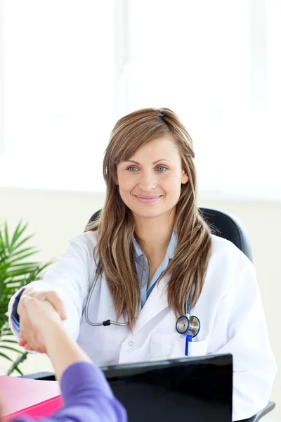 Привлекательная женщина-врач пожимает руку — стоковое фото